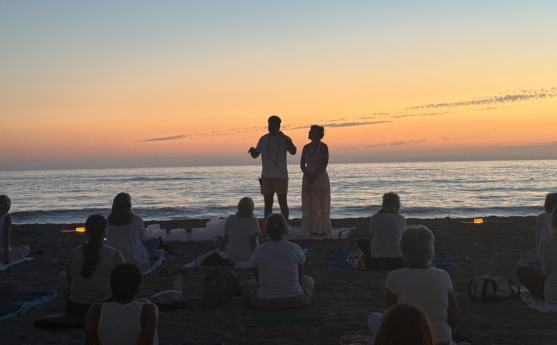 Kim Segal and Markandeya Rsi leading a sunset yoga and sound healing circle on the beach in San Diego