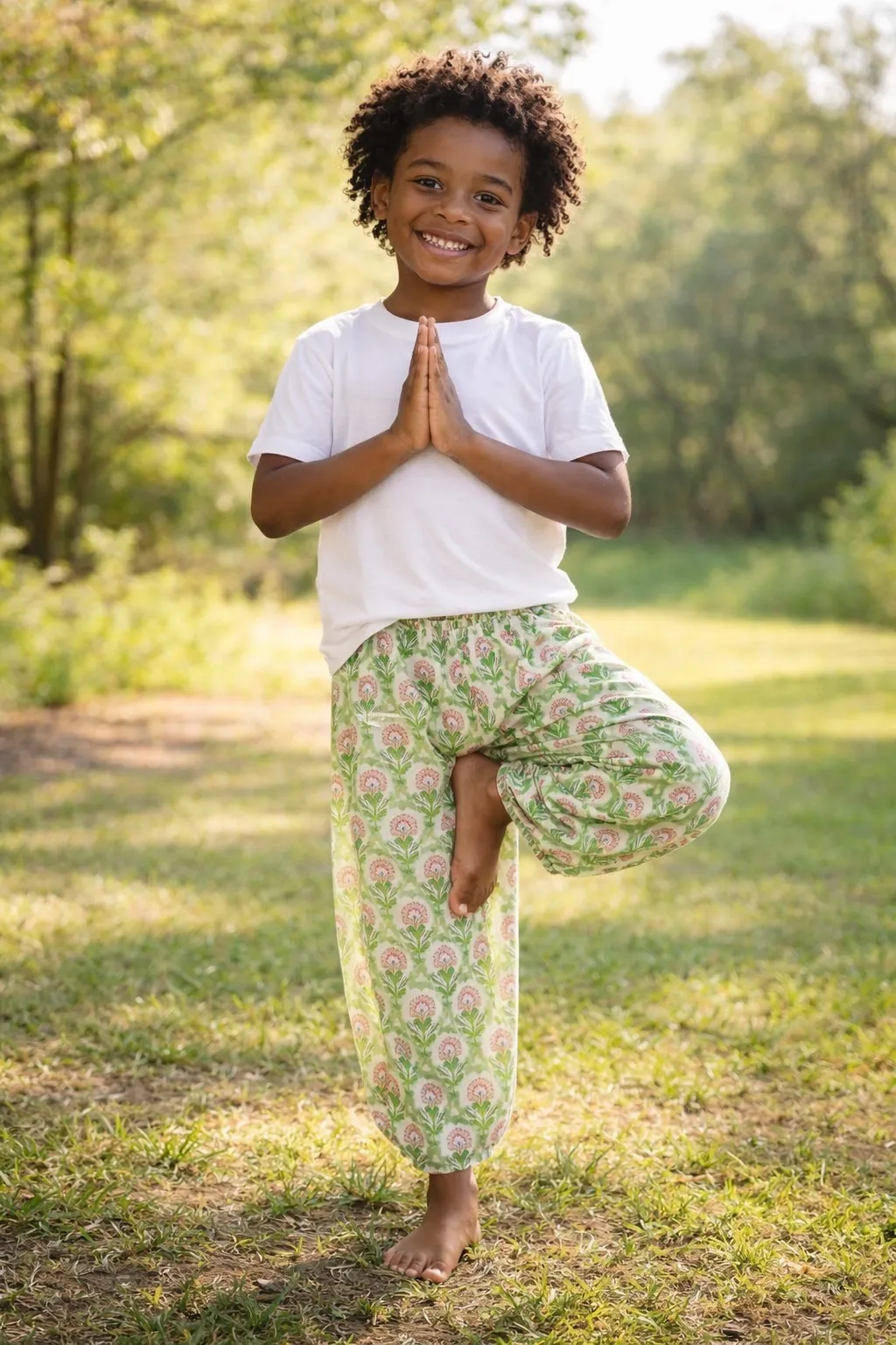 Child in tree pose wearing Little Bloom floral 100% cotton kids yoga pants
